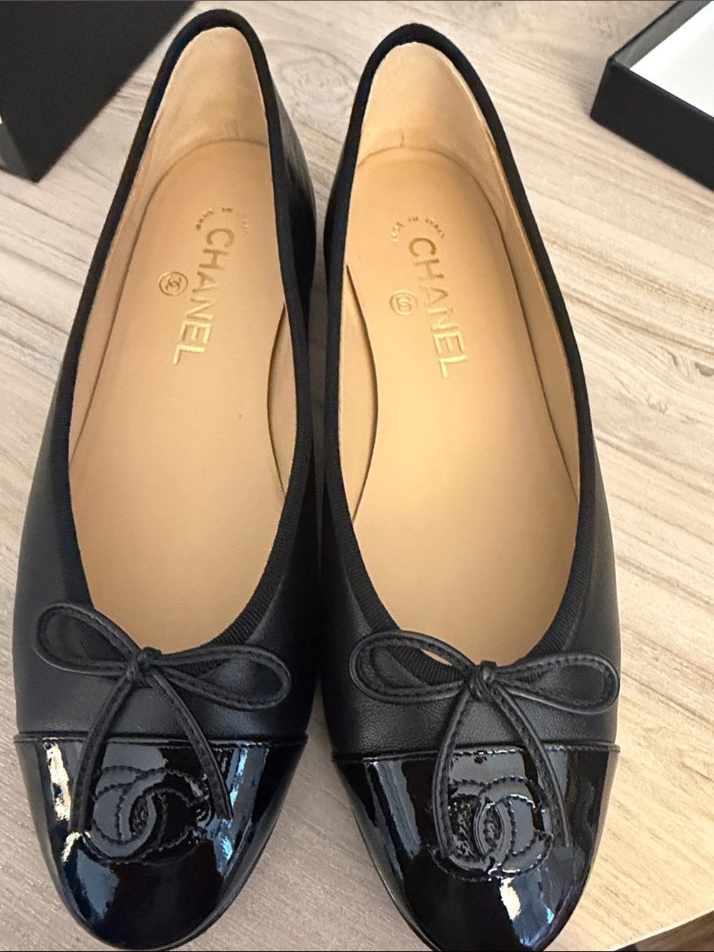 CHANEL Black Leather Ballet Flats with Patent Cap Toe and CC Emblem